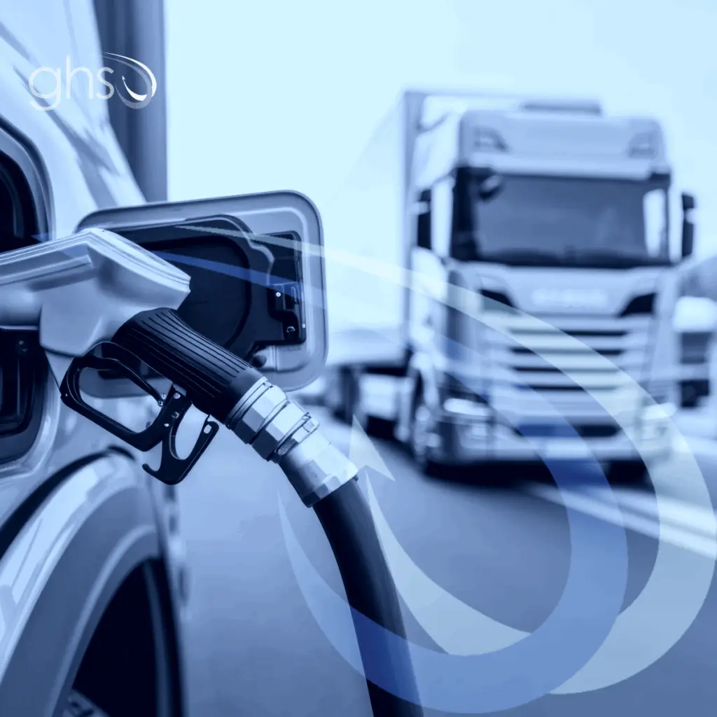 Truck fuelling near another trailer passing on main road